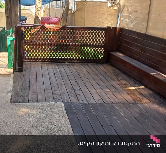 דק עץ עם ספסל ומחיצה מעץ בגינה